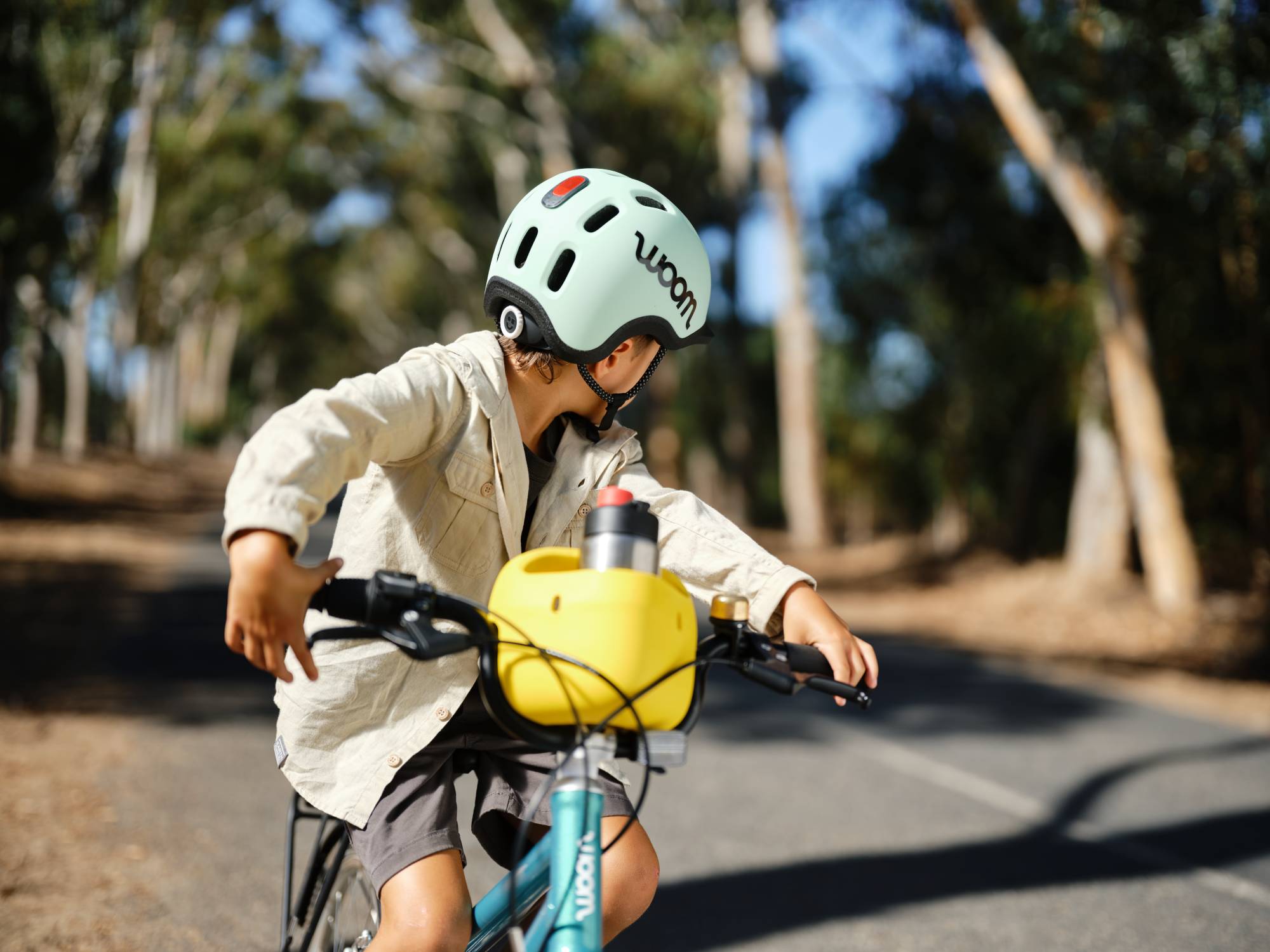 kluk na woom bicykli v prilbe Woom